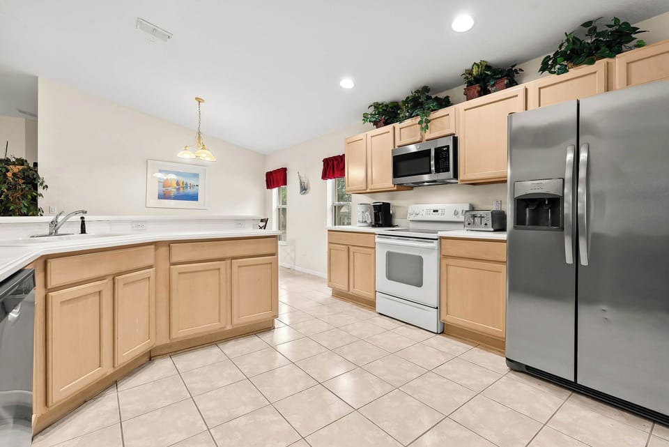 Spacious kitchen with light wood cabinets and stainless steel appliances for a comfortable cooking experience.