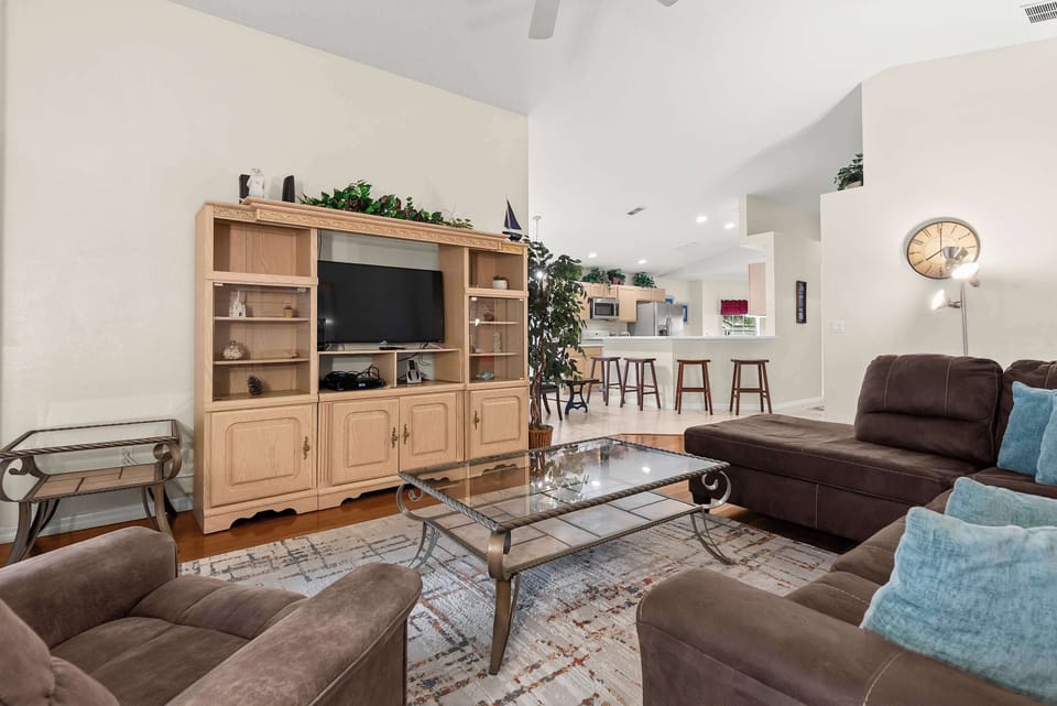 Open living area with vaulted ceilings and a view into the kitchen with bar seating.
