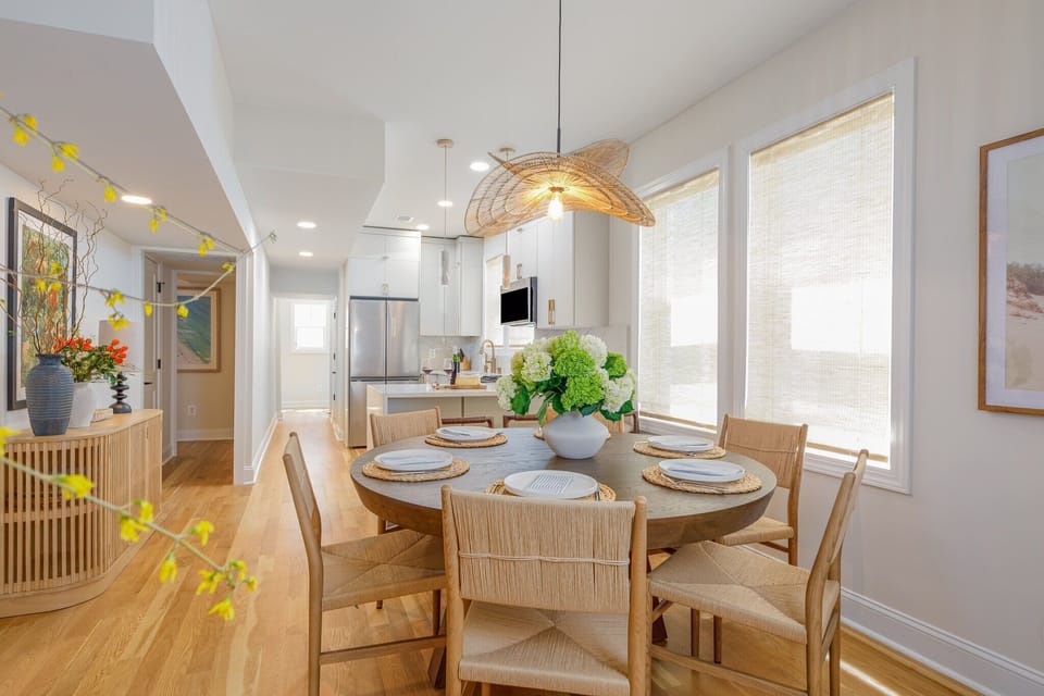 Right next to the kitchen is your dining area. Check out that trendy straw pendant light hanging over the table—it really brings the beach vibes inside.