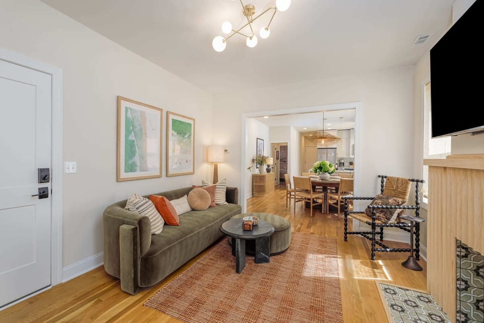 Step into the main living room, featuring a gorgeous designer green felt couch and a unique coffee table that makes the perfect conversation piece.
