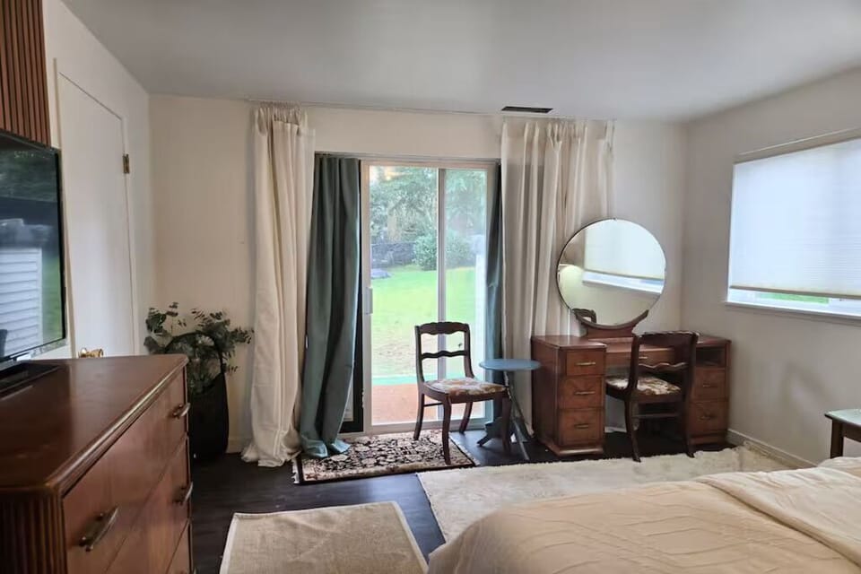 Spacious bedroom featuring a comfortable bed, dedicated vanity, ample storage, and large windows that fill the room with natural light. A peaceful retreat designed for rest and relaxation.
