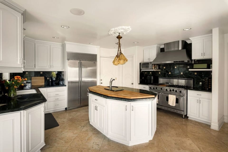 Fully equipped chef`s kitchen with stainless steel appliances, butcher block island, and elegant finishes.