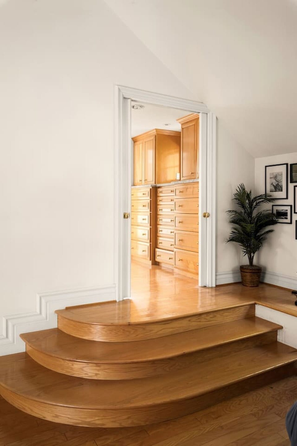Spacious walk-in closet with custom built-in drawers, ample storage, and warm wood finishes