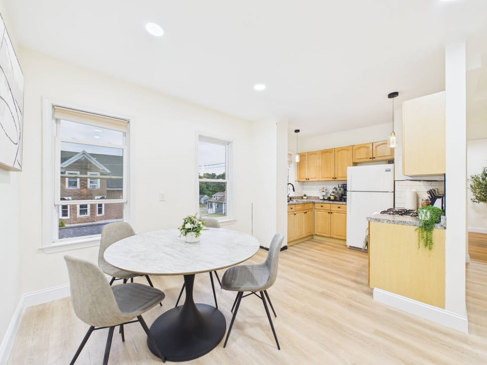 Bright dining nook and full kitchen with natural light and modern style