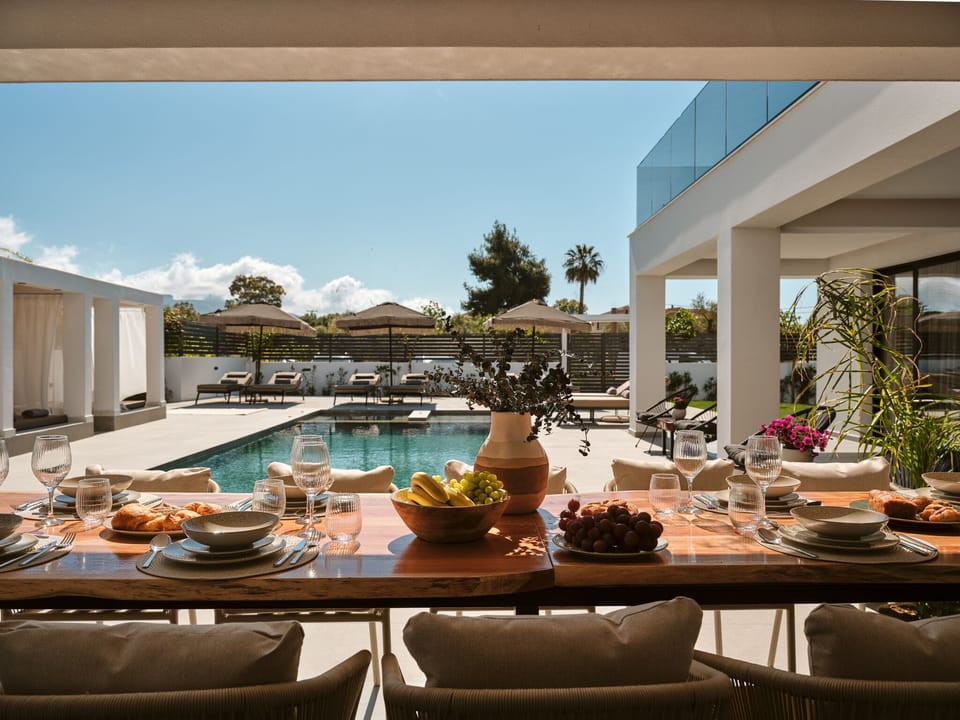 Poolside dining unfolds in the shade, where comfort, ease, and open-air living c