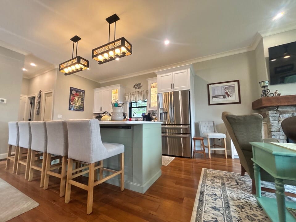 Gather around your spacious kitchen island with seating for everyone, where modern appliances meet warm rustic charm under statement lighting—perfect for morning coffee or evening conversations.