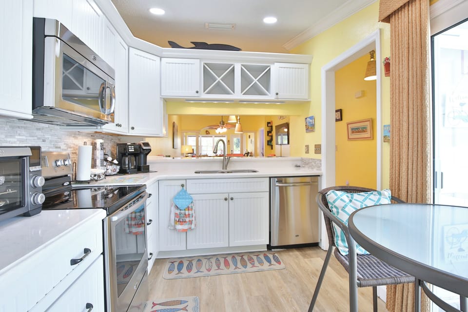 Your bright, fully equipped kitchen awaits—stainless appliances, ample counter space, and cheerful yellow walls to inspire your morning coffee or family dinners together.
