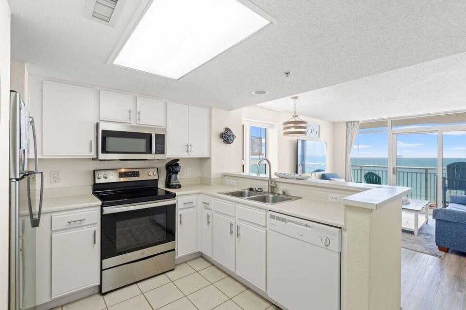 Stainless steel appliances fill this fully equipped kitchen, including a dishwasher, refrigerator, freezer, stove, oven, and microwave.