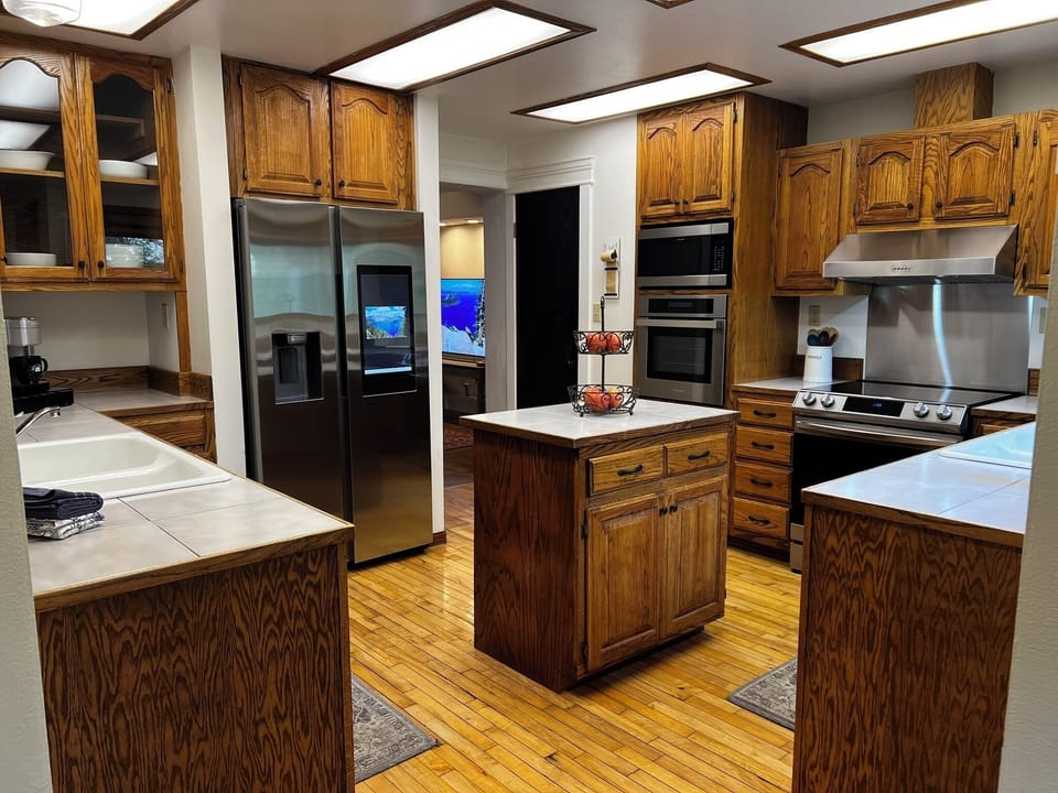 Spacious kitchen with island, stainless appliances, and warm wood finishes