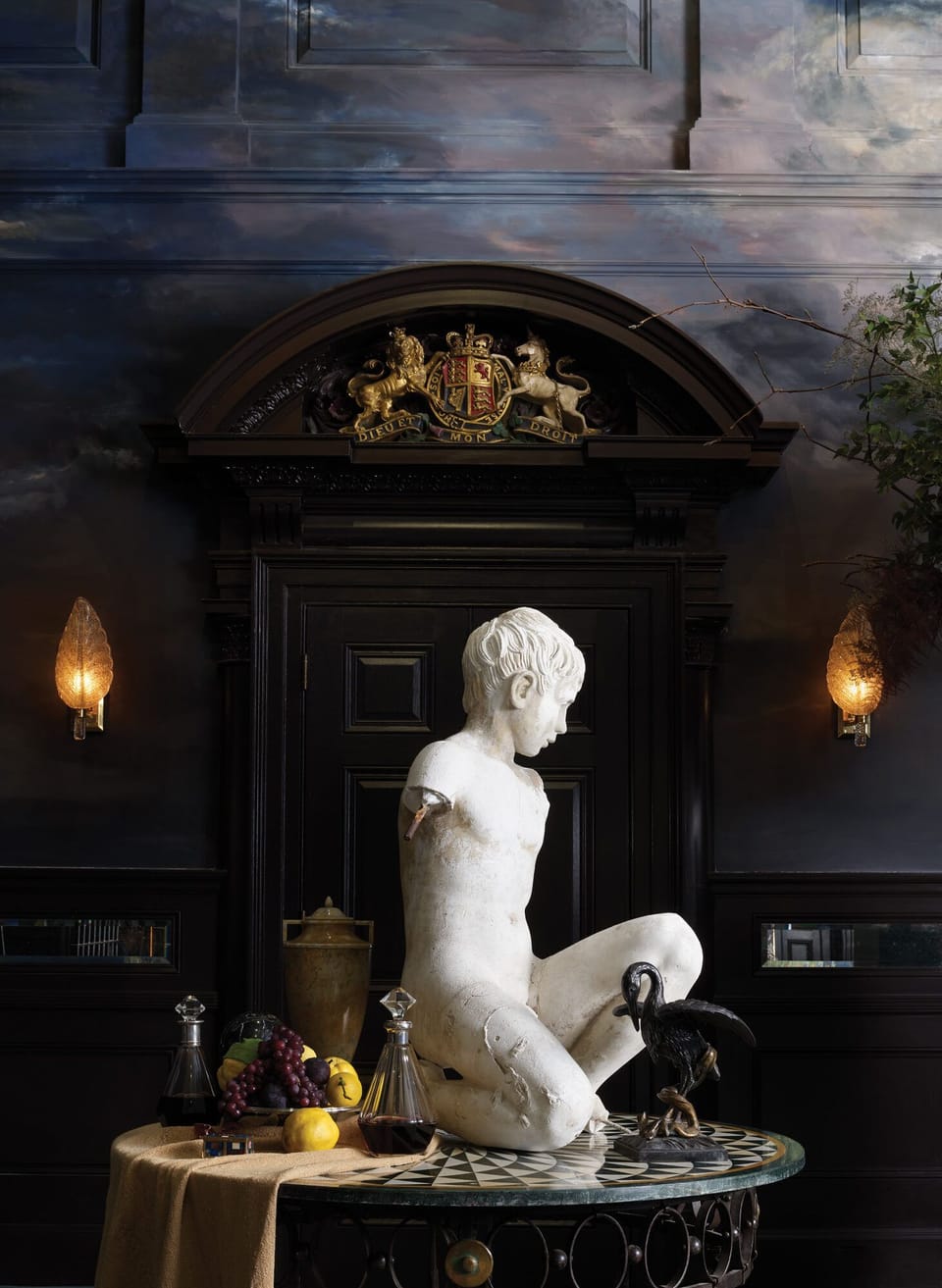 Casa Tua lounge — curated antique sculpture in moody library setting