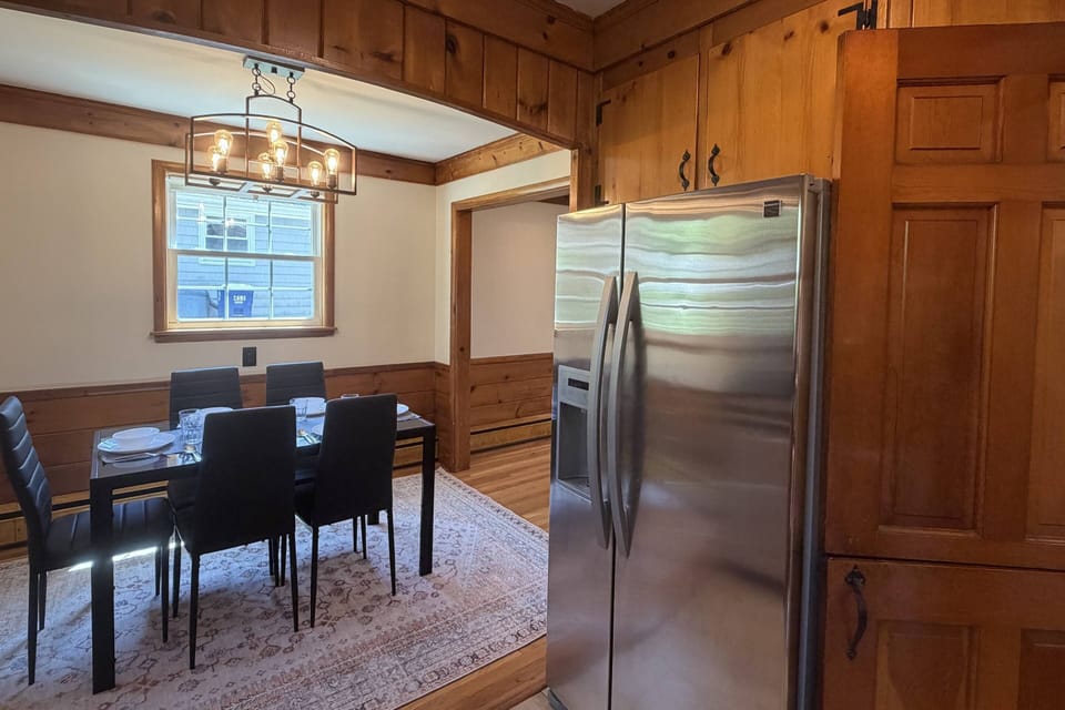 View of fridge in fully equipped kitchen and dining area