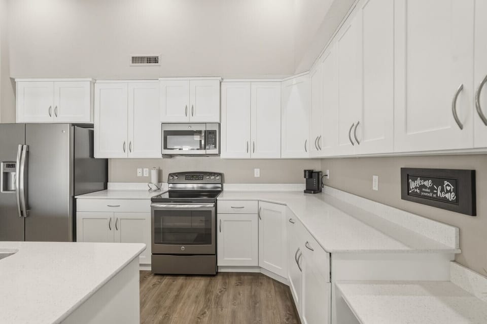Modern kitchen with stainless steel appliances, white cabinets, and ample counter space.