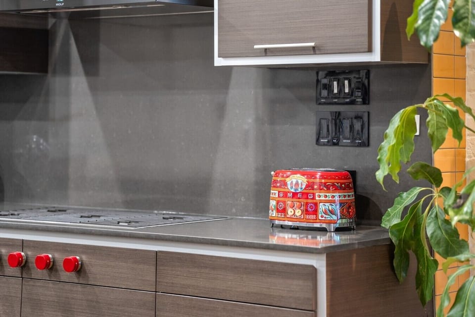 Modern Kitchen: Sleek design meets vibrant flair with a stunning SMEG toaster and chic finishes!