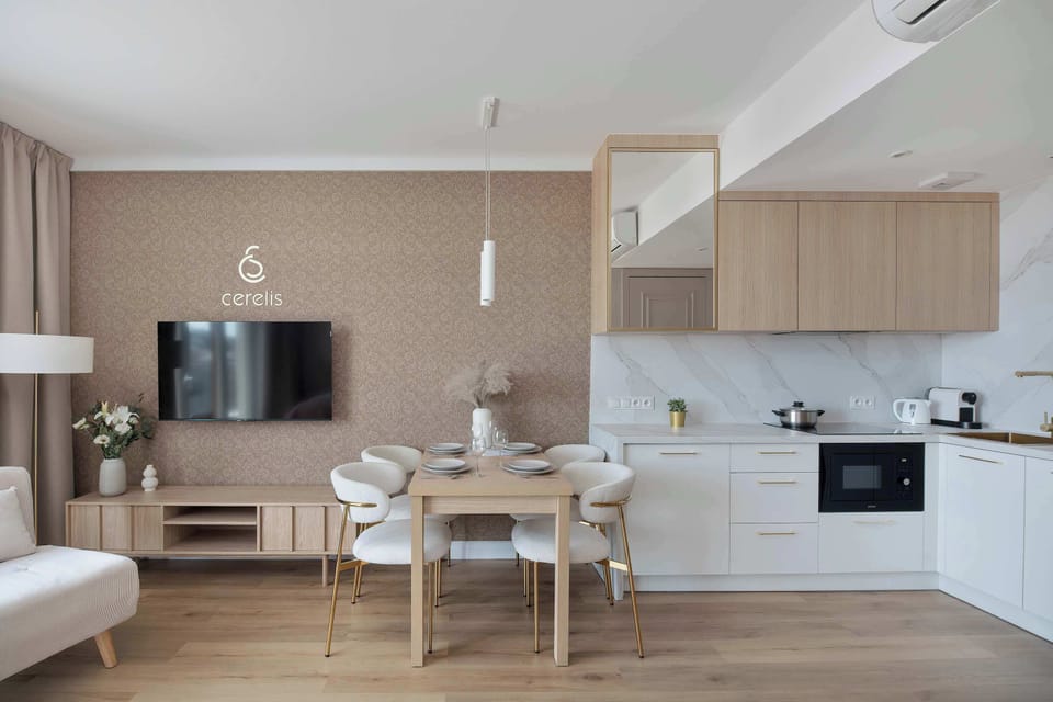 Modern living and dining area with a comfortable bed, TV, and fully equipped kitchenette.
