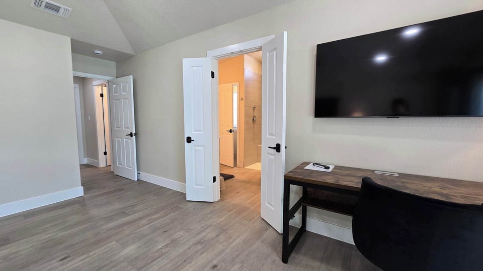 Bedroom 1 with king bed, patio, Smart TV, and ensuite 