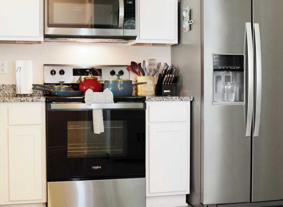 Kitchen with a modern fridge (water dispenser), oven, and cooking essentials.