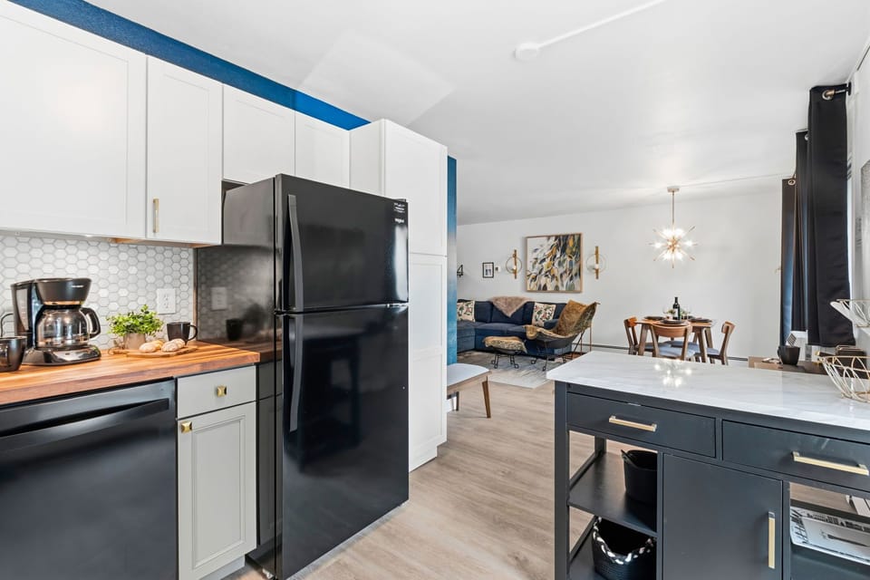 Modern kitchen flows seamlessly into a bright living and dining area. Natural light fills the room!