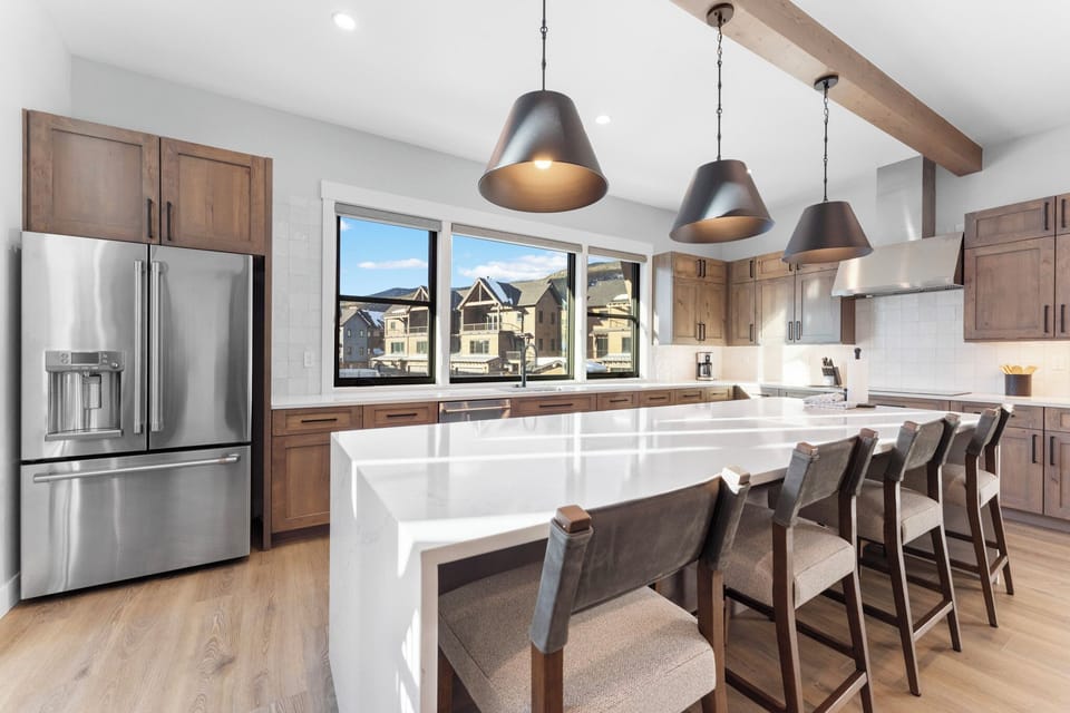 The full kitchen features double ovens, induction cooktop, and seating for 4.