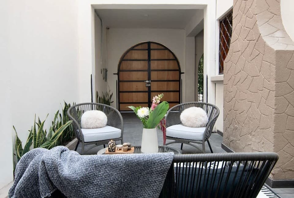 An inviting patio space with comfortable lounge seating and a warm, private atmosphere, ideal for gathering, chatting, or enjoying quiet moments outdoors.