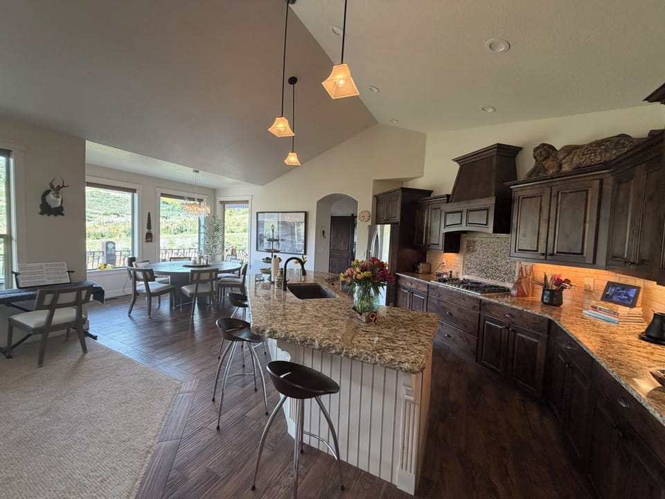 Open-concept kitchen and dining area with high-end finishes, granite countertops, and room for the whole group to gather.