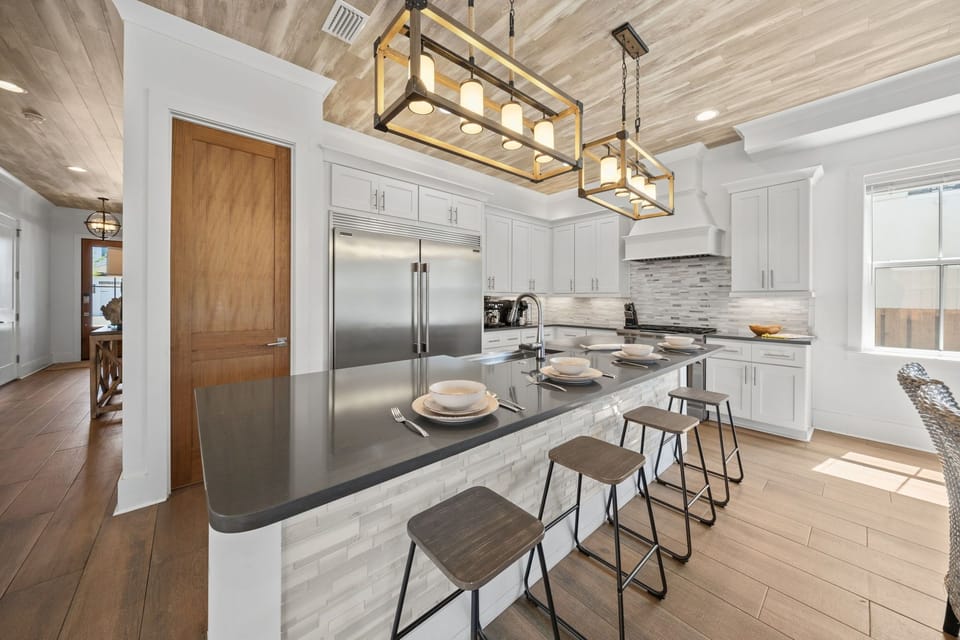 Four bar stools, a full stainless fridge, and everything you need for a week of cooking in — the kitchen works as hard as you want it to.