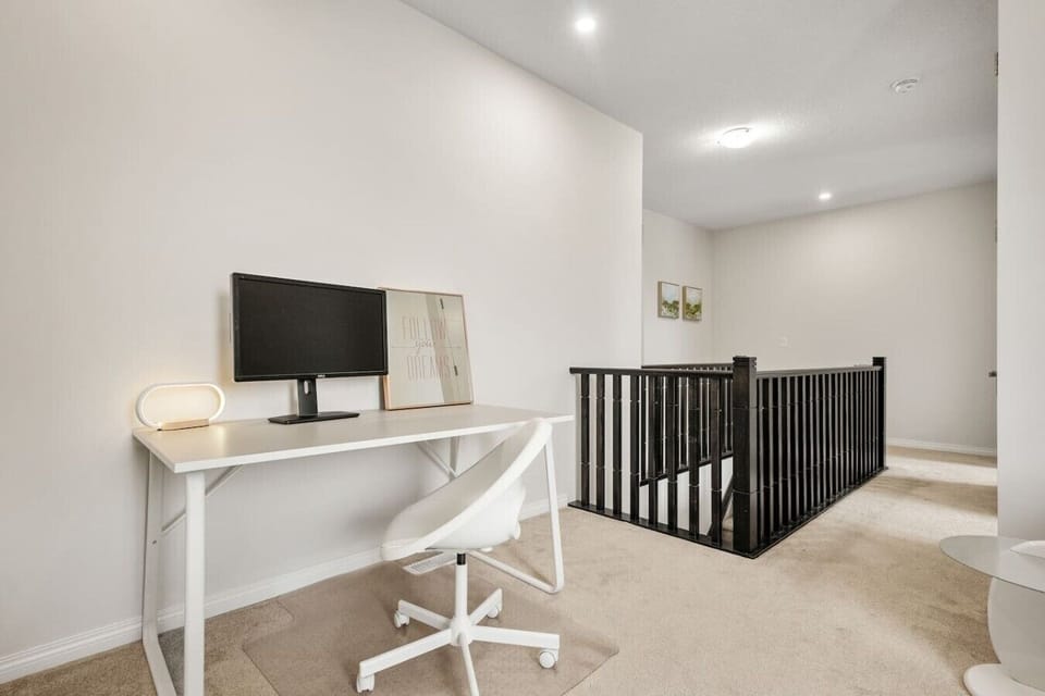 Upstairs loft featuring work desk, monitor setup, and enclosed play space