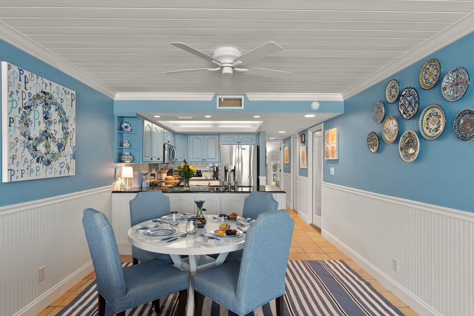 Alternative angle of the formal dining layout, highlighting the beach-house aesthetics and striped area rug.