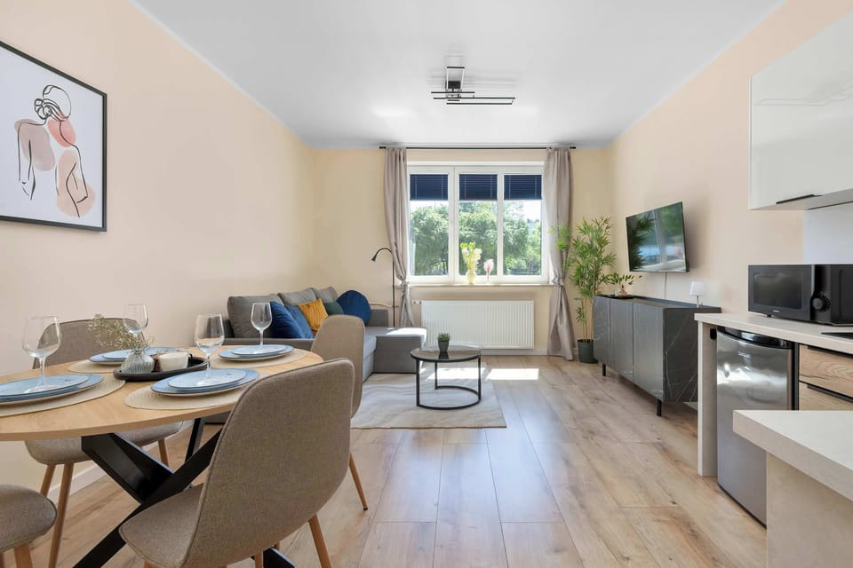An open-plan interior combining the kitchen, dining area, and living room. Large windows bring plenty of daylight into the space.