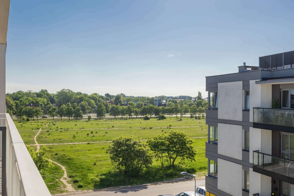 A scenic view of green fields and open landscape seen from the property. The setting emphasizes a peaceful and natural environment.