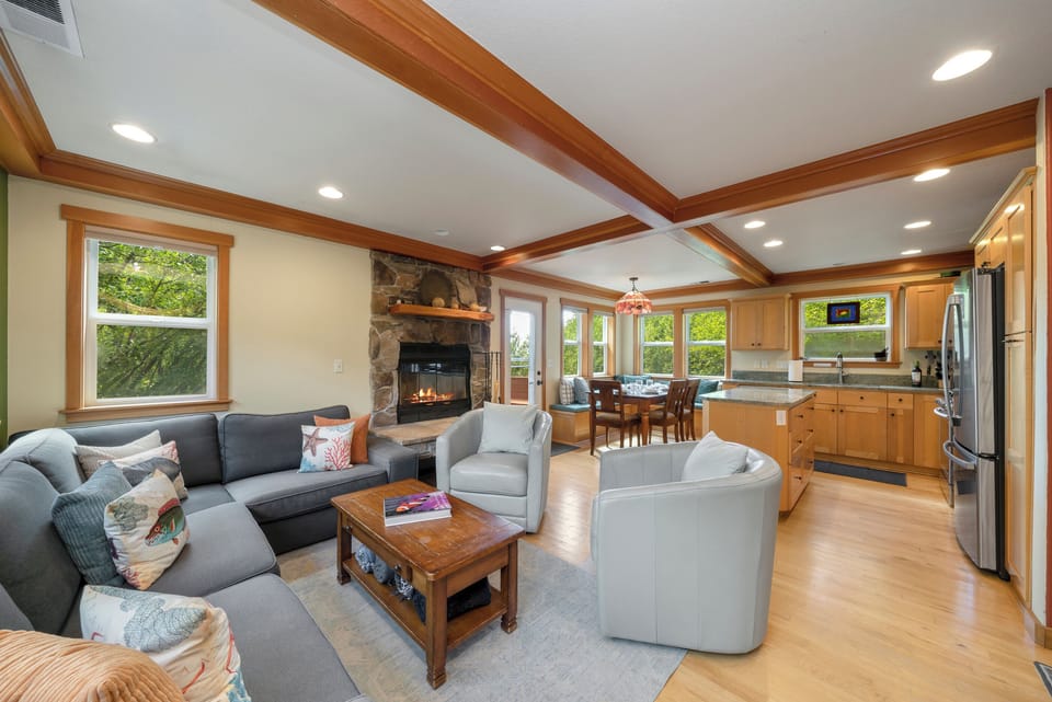 Open living space with wood fireplace, dining nook with bench seating, fully equipped kitchen.