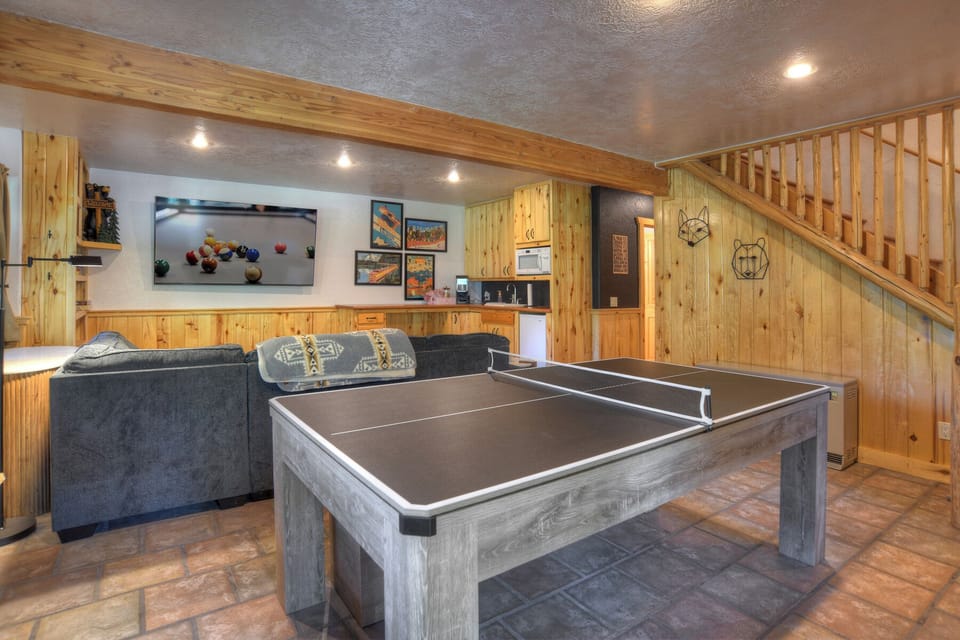 The downstairs area is complete with billiards, ping pong, a puzzle table, big screen TV, and popcorn machine for movie night.