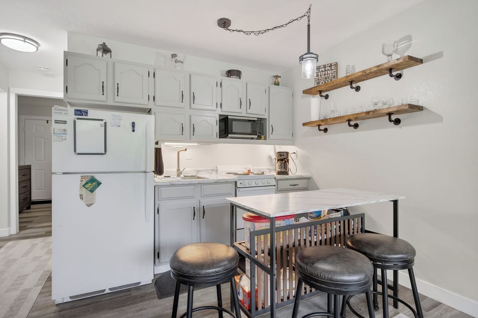 Step into your fully equipped kitchen with charming rustic touches, open shelving, and a convenient breakfast bar—perfect for morning coffee or prepping meals together.