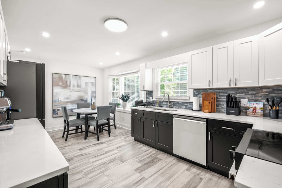 A fully equipped kitchen that actually makes you want to cook — sleek two-tone cabinetry, stainless steel appliances, generous counter space, and a sunny dining nook just steps away make this the heart of the home.