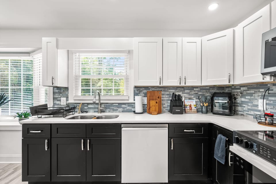 Cook like you're home — this beautifully designed kitchen features striking two-tone cabinetry, a mosaic tile backsplash, and all the appliances and counter space you need to whip up anything from a quick breakfast to a full group dinner.