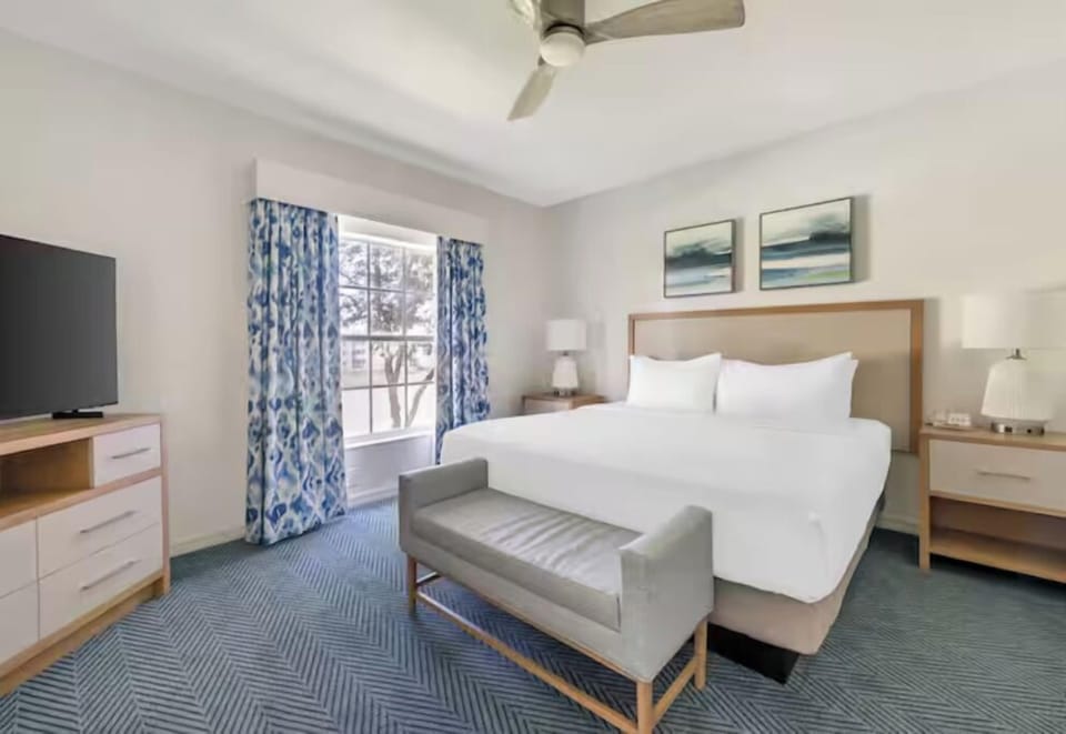 Unwind in a bright bedroom with crisp linens and calm tones.
