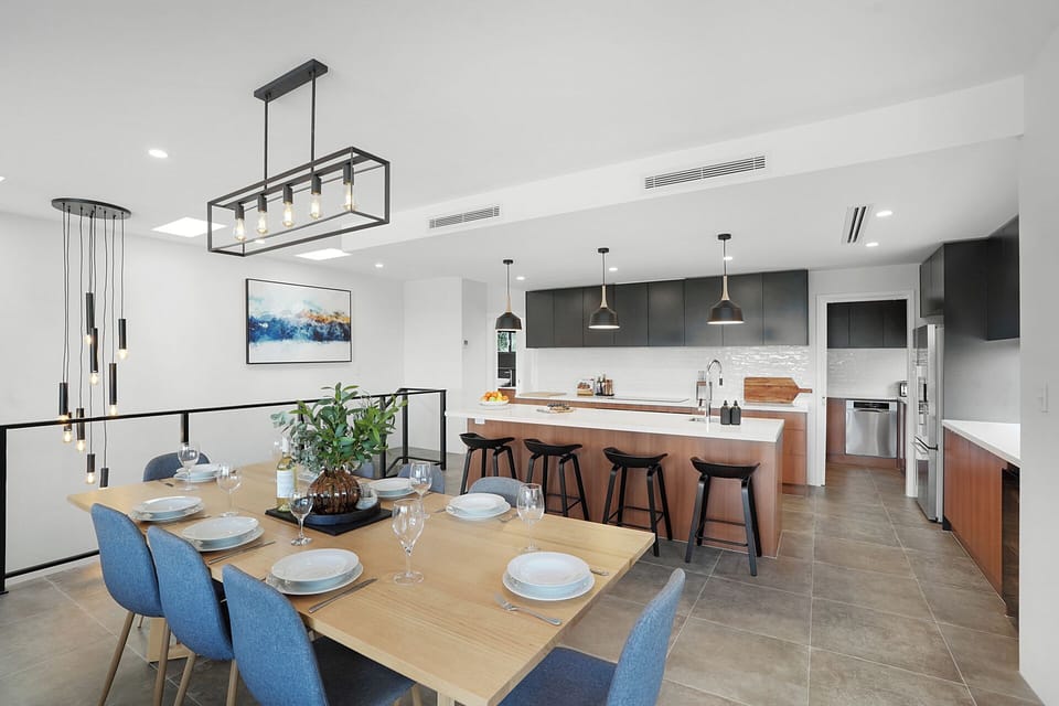 Modern dining space flowing effortlessly into a sleek, fully equipped kitchen.