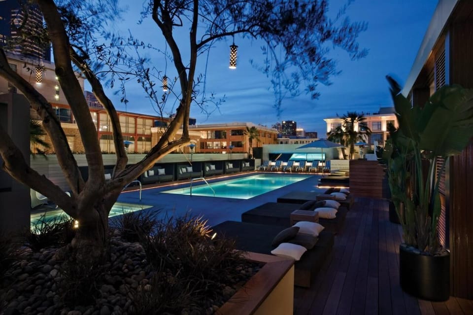 Unwind poolside on cushioned loungers under twilight lights.