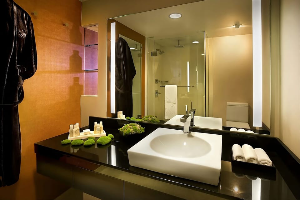 Refresh under glowing mirrors with plush towels and sleek vanity.