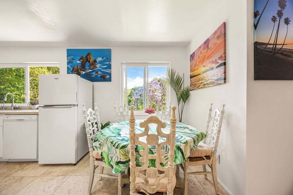 Cozy dining nook with natural light, tropical décor, and seating for relaxed meals together.