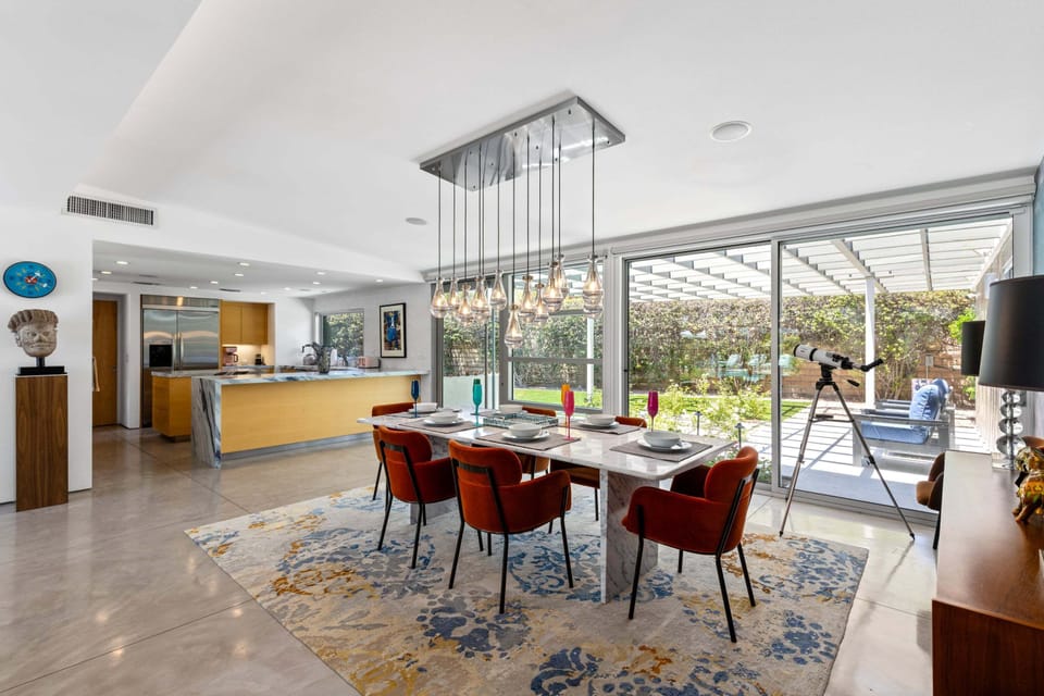 Patio seating can be found through additional sliding glass doors. Kitchen area can also be seen directly from the dining area.