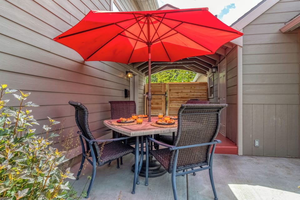 Outdoor dining table and umbrella create a comfortable place to gather.