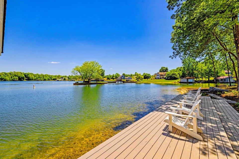 Dock & Boathouse - Two Adirondack chairs perch at the dock's edge facing wide open water, ideal for morning coffee over the glassy lake.