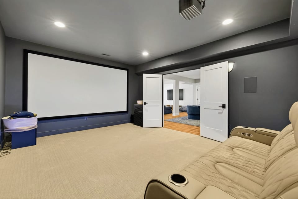 Movie Theater - Two tiered rows of leather recliners face a wall-sized projector screen for true movie nights.