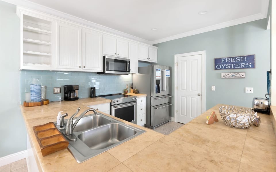 Bright coastal kitchen with stainless appliances, beachy decor, and plenty of counter space for easy meals.