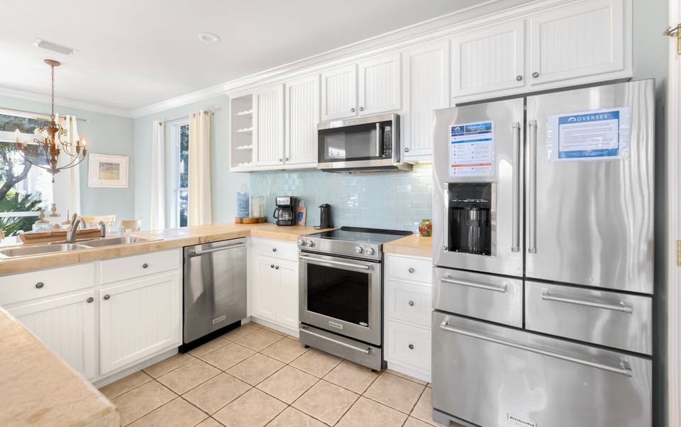 Bright coastal kitchen with stainless appliances, beachy decor, and plenty of counter space for easy meals.