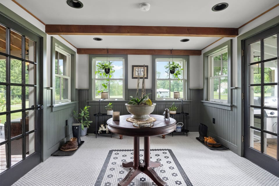 Symmetrical sunroom or entry hall with garden-facing windows and classic checkered flooring.