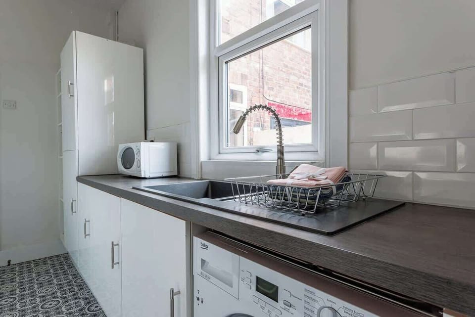 Prepare meals with ease in this practical kitchen featuring generous worktop space, modern cabinetry, and everyday appliances. The streamlined layout keeps cooking essentials within easy reach while creating a comfortable environment for daily use.