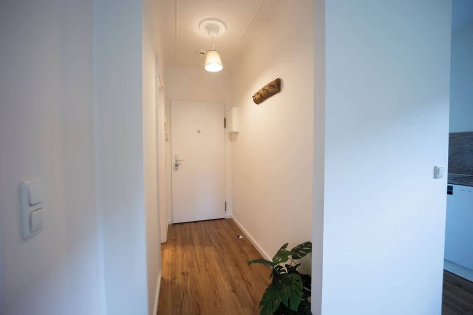 Der Eingangsflur mit Garderobenhaken aus Holz begrüßt dich