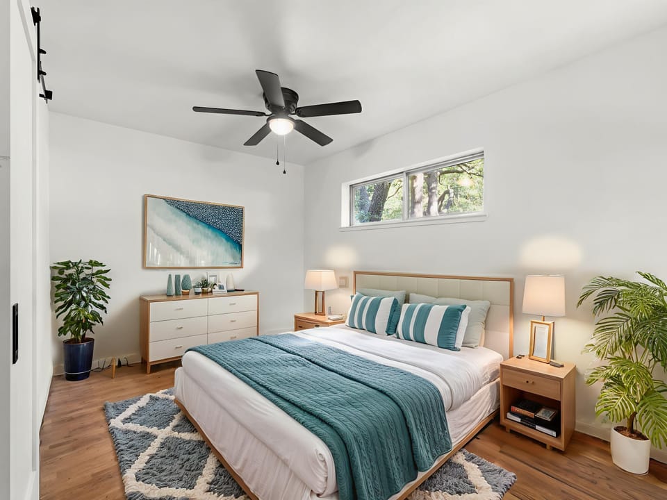 Drift off in your serene bedroom with ocean-inspired decor, warm wood tones, and lush plants creating a peaceful retreat.