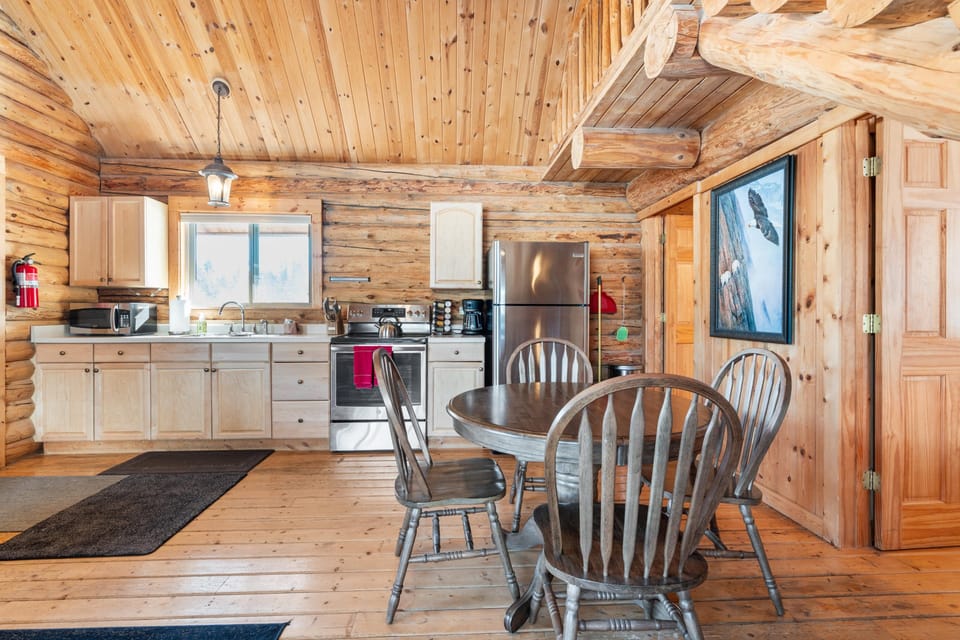 Open plan kitchen with dining area, wood cabinets, and stainless steel appliances.